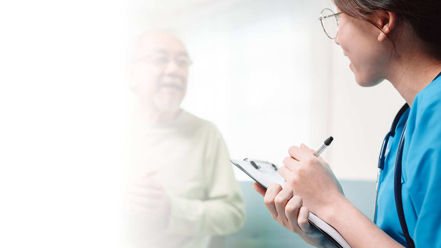 Nurse writing notes while talking to a patient