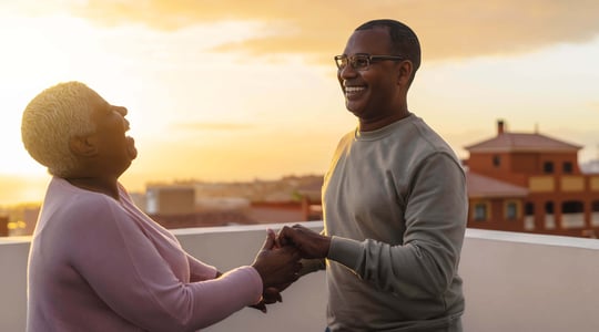  Casal dançando em um telhado contra um pôr do sol